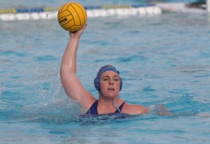 Allie Steward with arm raised yellow ball in hand ready to throw in the pool, wearing blue.