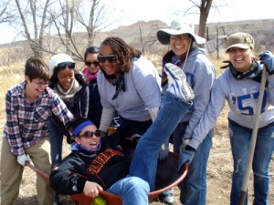 Students and staff pose with a wheelbarrow and tools in the Dine' (Navajo) Nation. Photo by Angela Gonzaga.