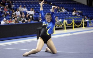 Katie Valleau, female gymnist, on the floor mats during routine. Finishes off routine with hands in the air. 