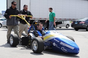 Two students push out a hybrid racecar, with a student inside, at the 2011 Formula Hybrid Competition in New Hampshire. Photo by Kathryn LoConte Lapierre.