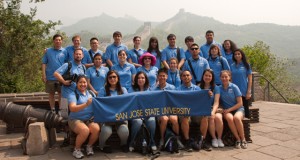 SJSU students and faculty wear matching blue polo shirt and hold a SJSU banner at the Great Wall of China as part of the 2011 Global Technology Initiative trip. Photo by Clifford Wong.