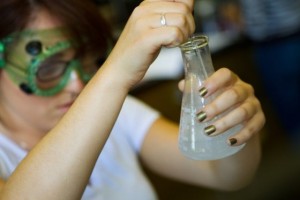 Female student mixing chemicals in a beaker.