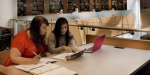 Two students working together on laptops at King Library