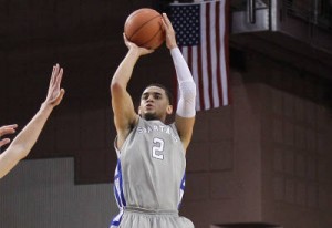 SJSU Alum Adrian Oliver takes a shot in a Spartan uniform with the American flag hanging behind him.