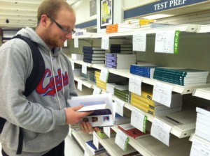 A student stands in front of books to rent in the bookstore