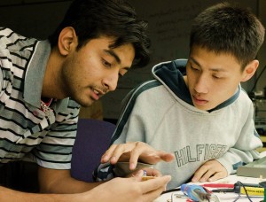 Killol Acharya working with a fellow student on an engineering project.