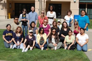 SJSU Faculty, Staff, and Student Pose for a picture on the grass in The Village Quad