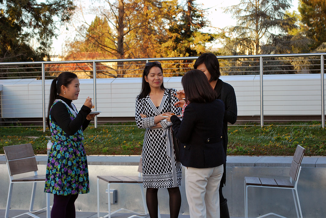Health Science Professor Jane Pham, second from the left, and Social Work Professor Meekyung Han, second from the right, talk with visitors from Vietnam during the Social Work Education Enhancement Program Fellows' reception March 4 on the Yoshihiro Uchida Hall rooftop terrace.