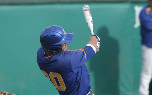 Michael DiRocco seconds after swining the bat. He is wearing a blue helmet and a blue jersey with a white baseball bat.