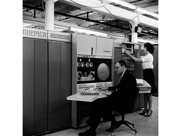 Gordon Bell typing on the keyboard of a computer the size of a refrigerator.