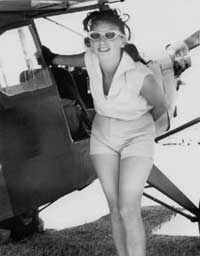 Black and white photo of Amelia Reid with an airplane.