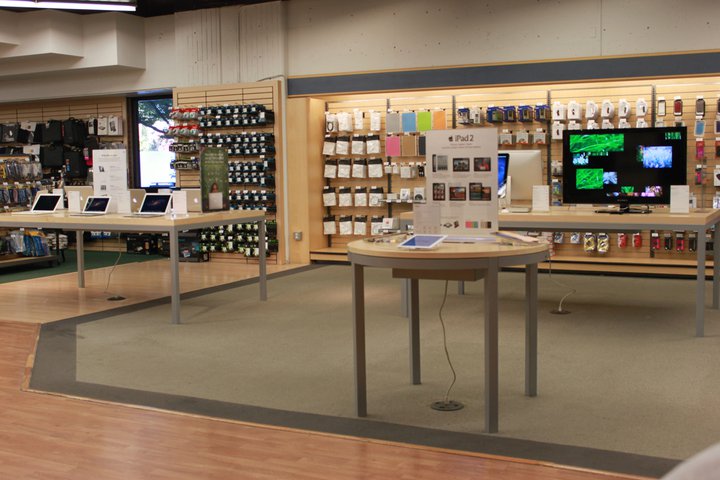 A picture of the technology including demonstration tables that feature Apple products, inlcuding IPad 2's and MacBook Pro Air
