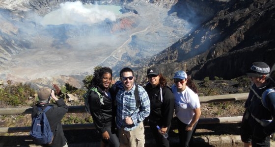 4 students standing before steaming volcano