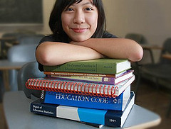 teaching student resting in pile of books