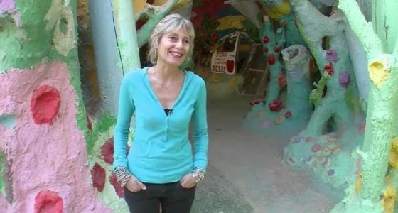Jo Farb Hernandez at Salvation Mountain, which is 3 stories high, and very brightly colored, with written and visual messages.