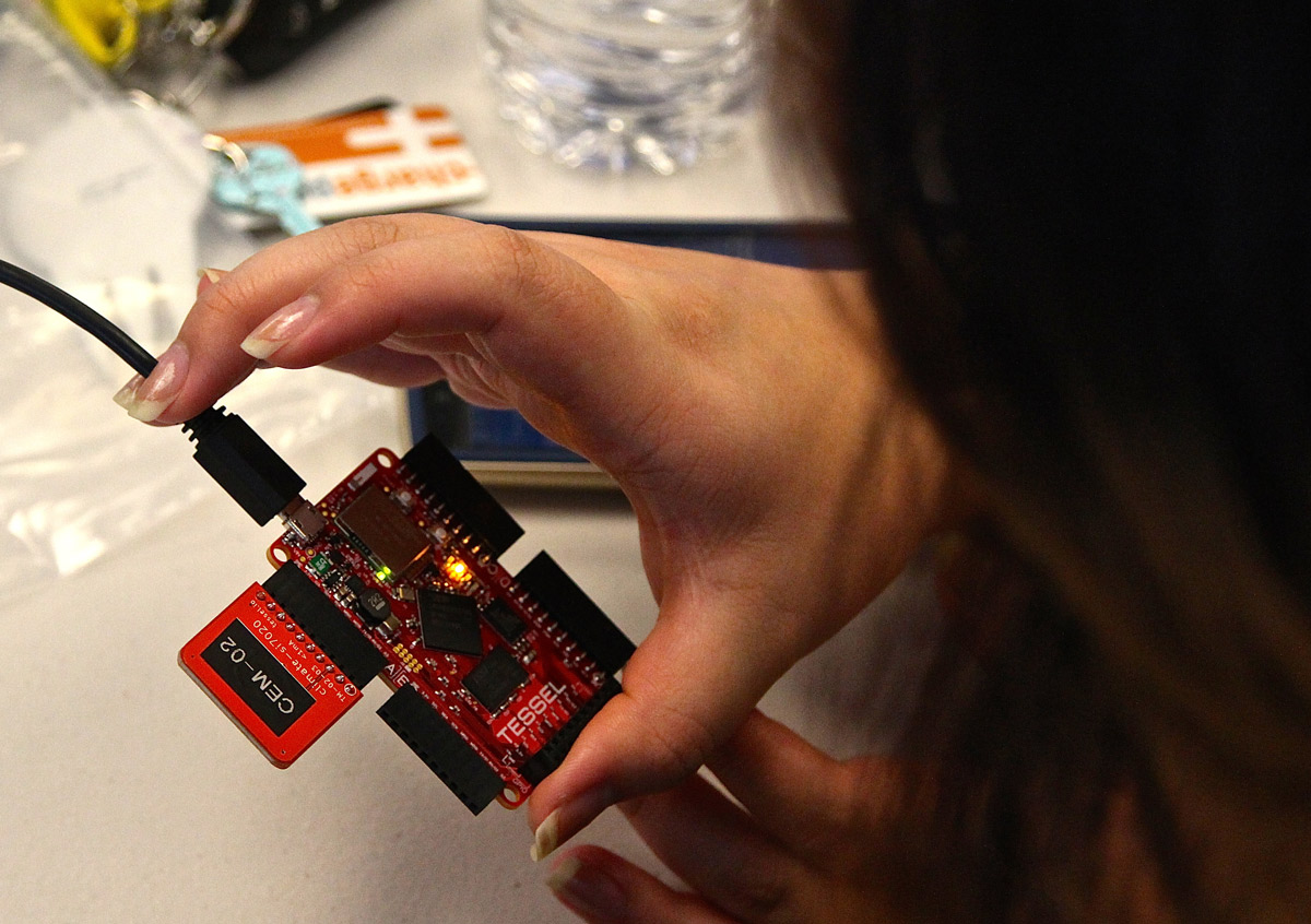 Meredith Ku, VMware intern, takes a closer look at a blinking Tessel Board as it connects to her laptop (Photo: Lauren Hernandez, ’15 Journalism).