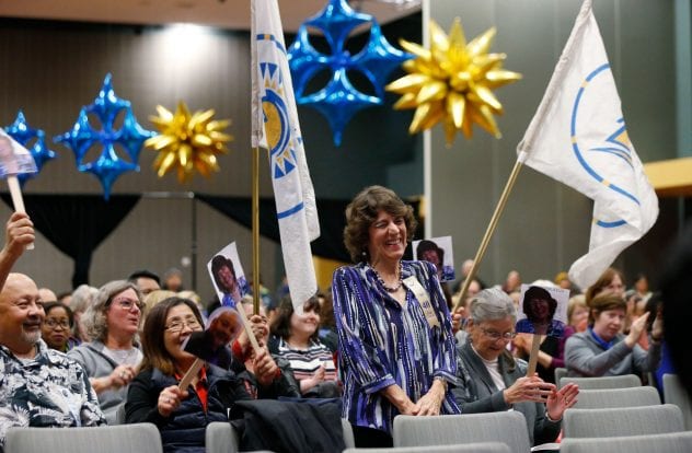 Sharon Brook, an accompanist, is cheered for 40 years of service by colleagues with Spartan banners. ( Josie Lepe/San Jose State University )