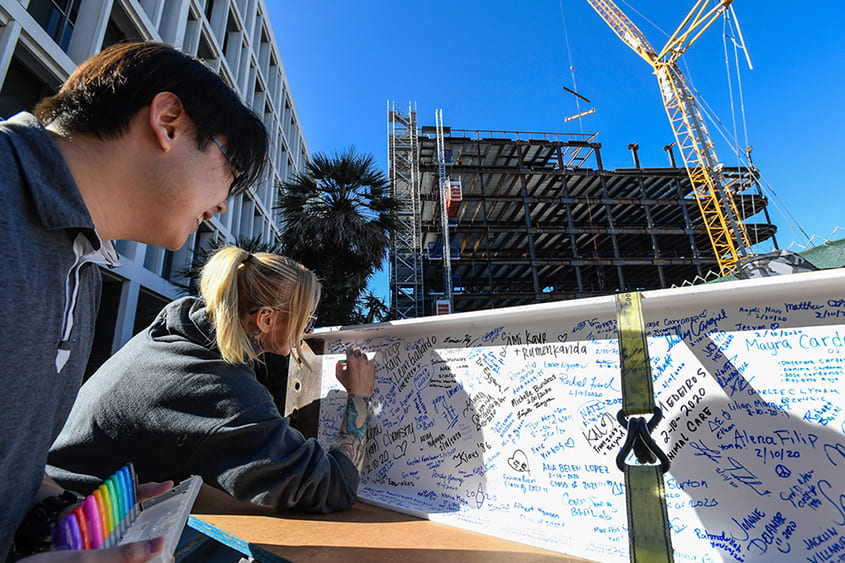 SJSU students sign their names for the topping out event.