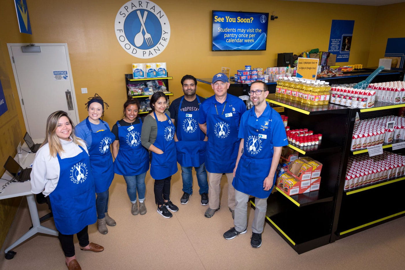 Food Pantry employees in blue aprons.