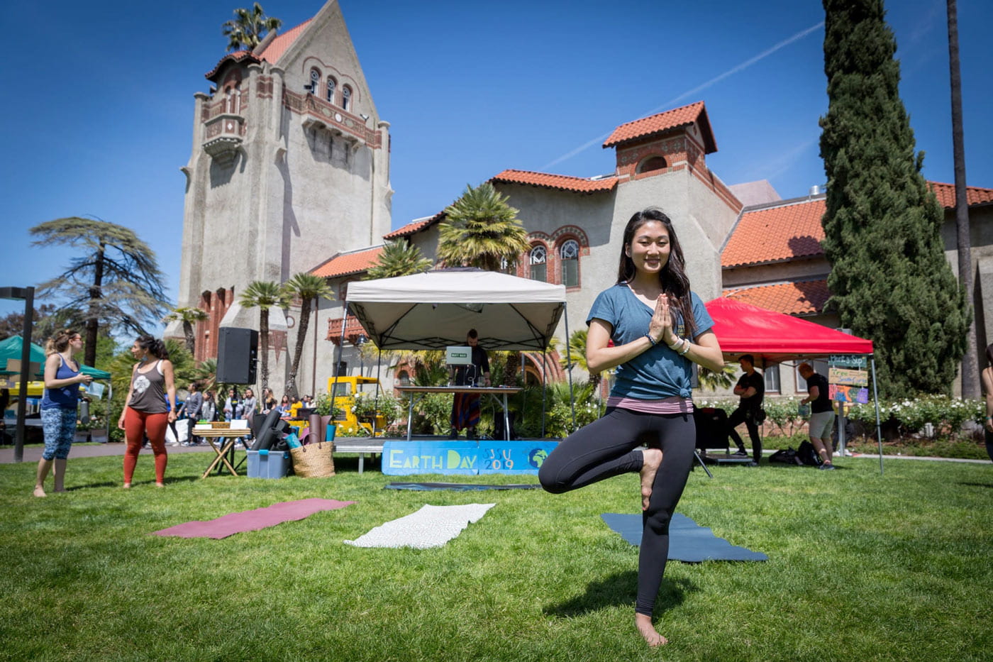 Student on the tower lawn doing a yoga pose.