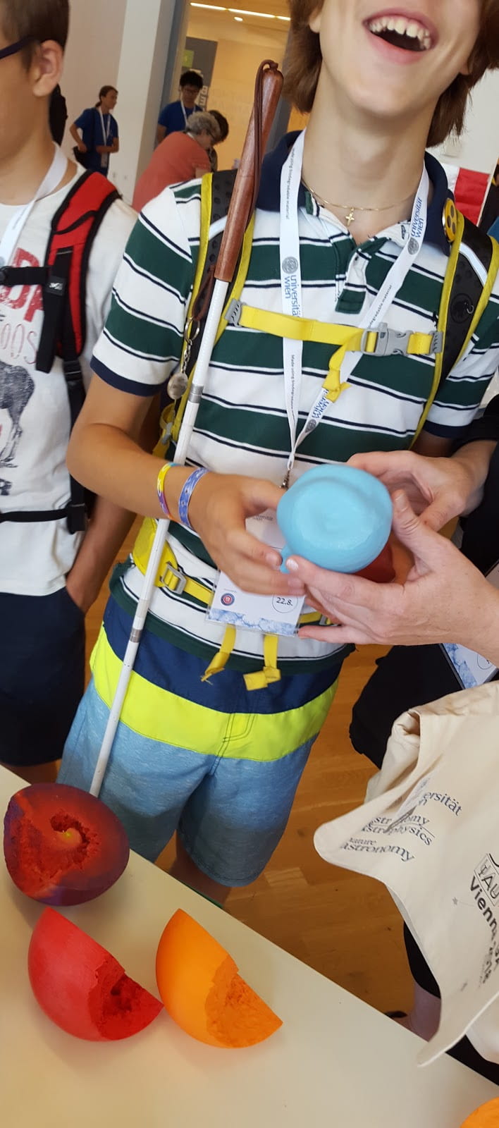 A student with visual impairment holds a 3D printed model of the Eta Carinae Homunculus nebula.