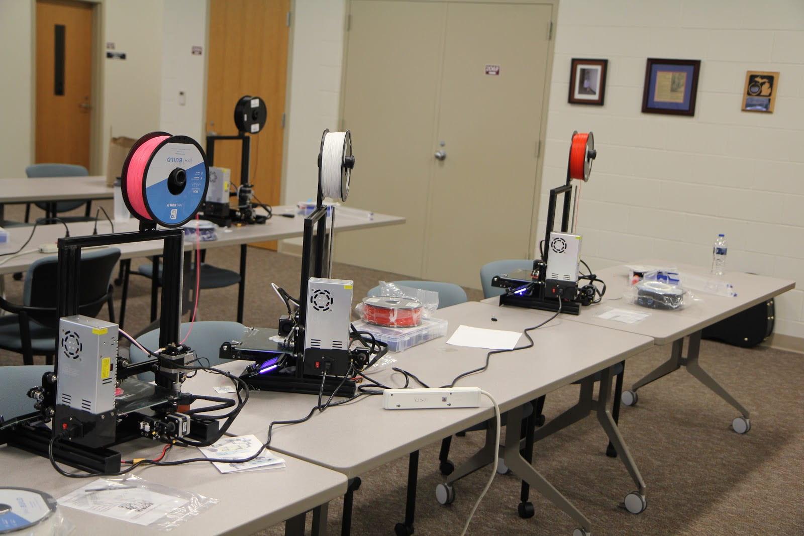 Multiple 3D printers assembled by students with visual impairment. 