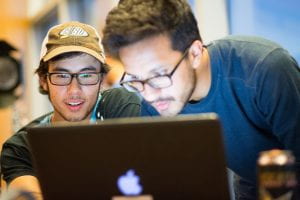 Two students using Apple laptop