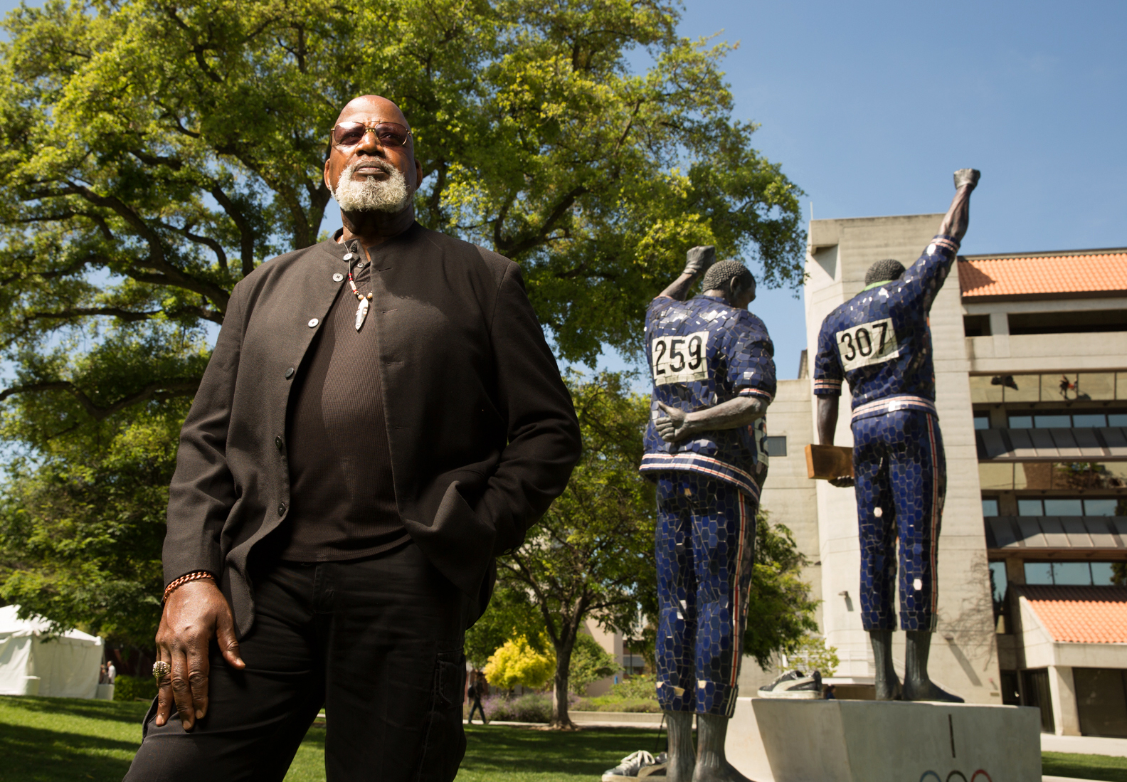 Harry Edwards looks up to the Smith/Carlos Sculpture on campus.