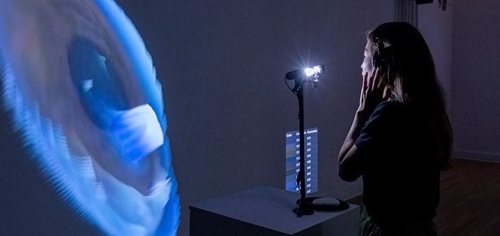 Designer Yoon Chung Han's stands in front of a machine that scans and projects an image of your iris.