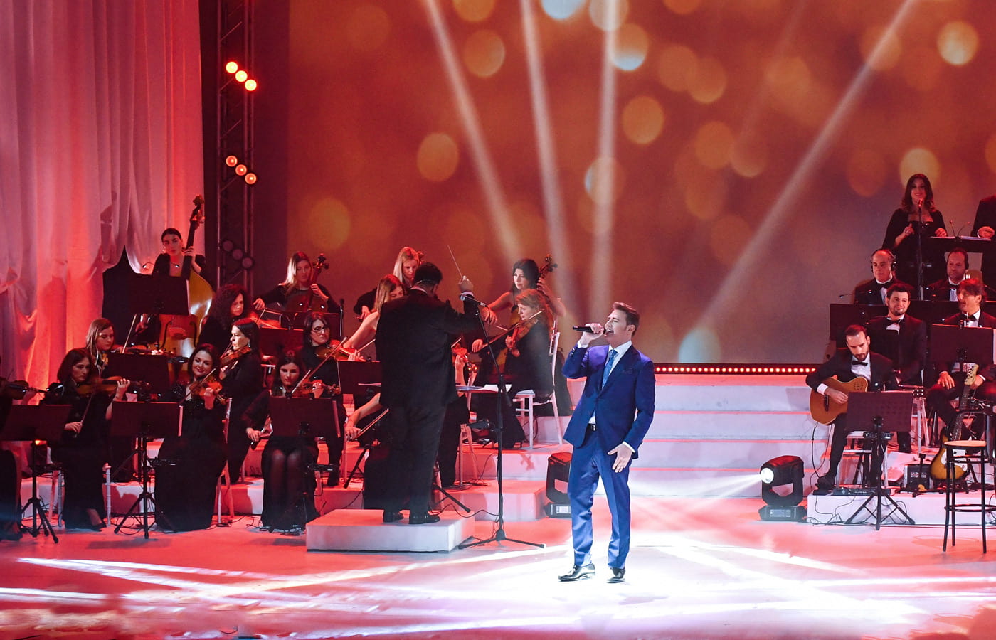 Pasquale Esposito singing on a glittering red stage.
